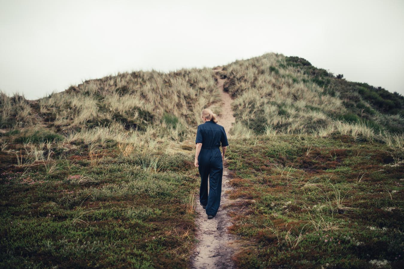 Kvinde går ved klitter