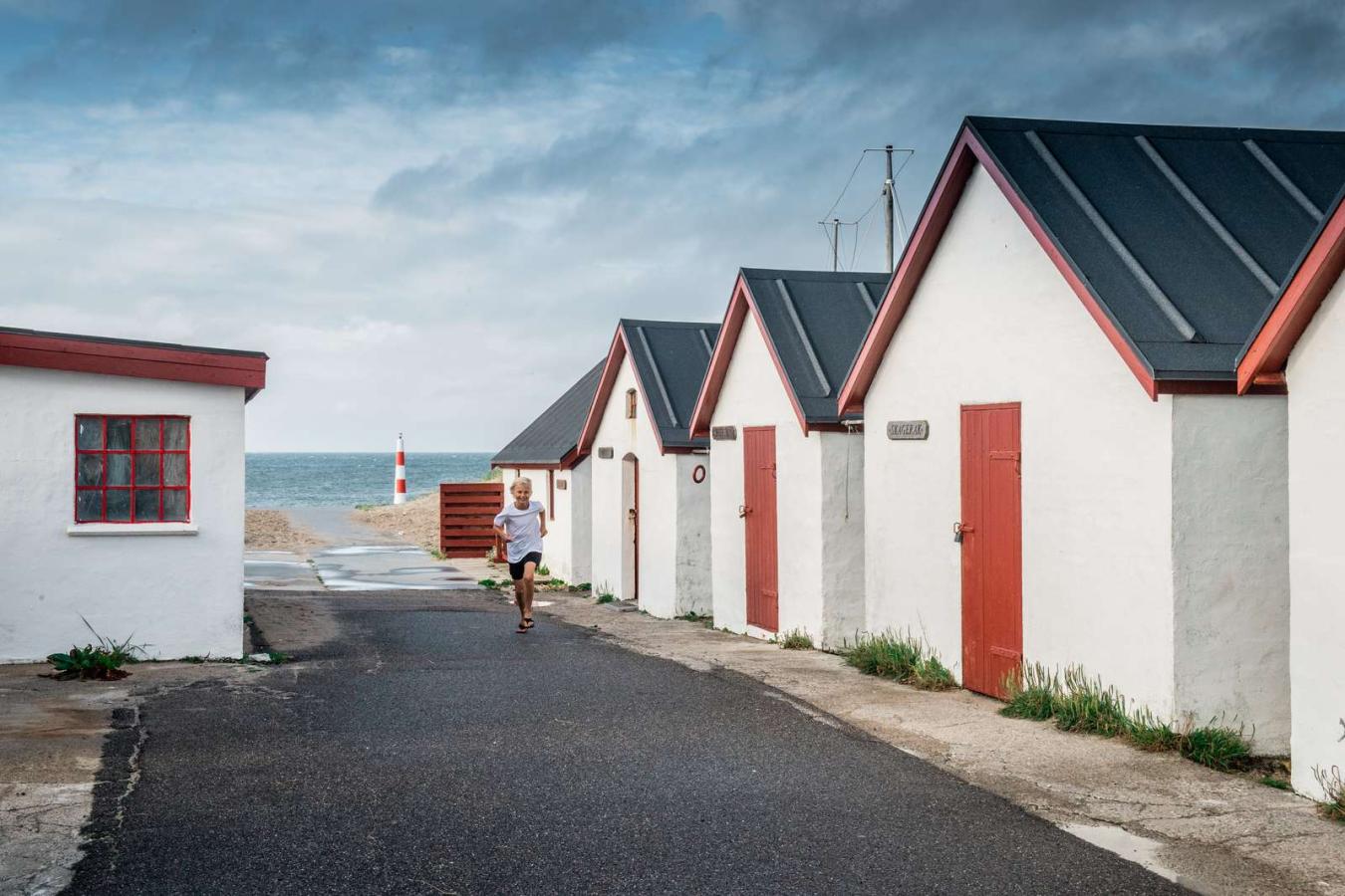 Dreng løber ved huse i Klitmøller