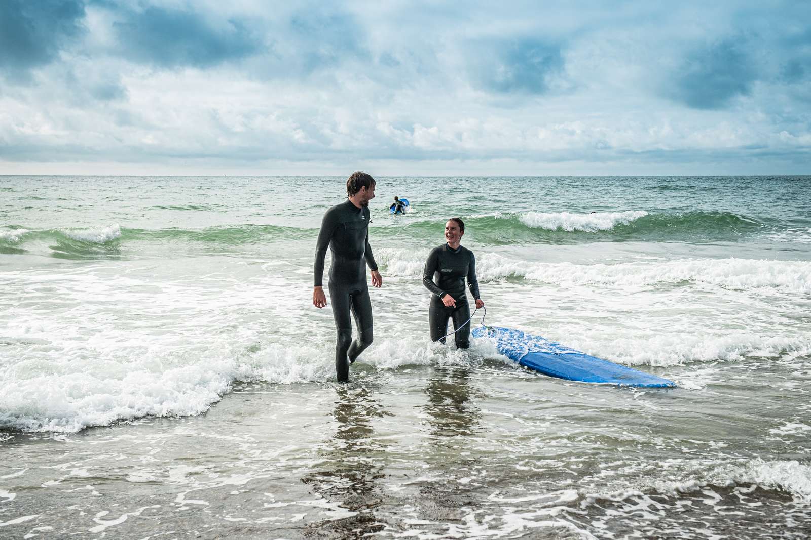 To mennesker der surfer i Vesterhavet 