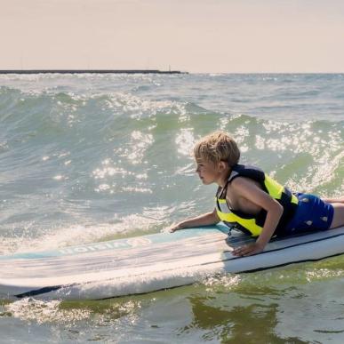 Dreng på surfboard i Løkken